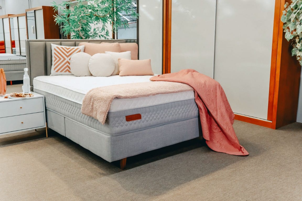 Cama Box Premium Cremona Látex e Duplo Molejo Conjunto box casal Cremona montado em um quarto de luxo, destacando a altura do colchão e a base elegante.