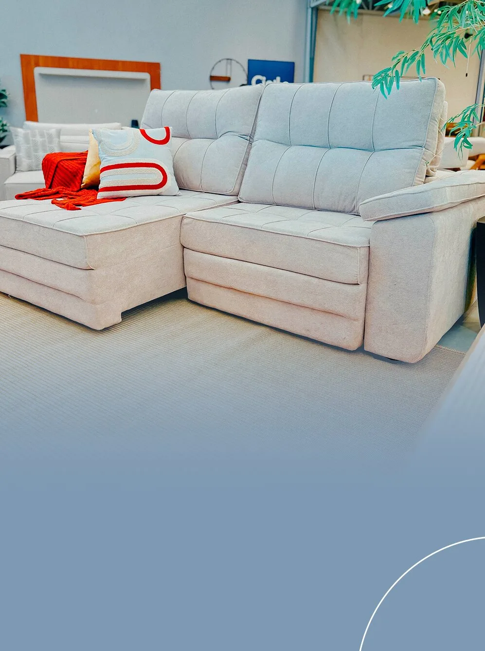 Sofá retrátil e reclinável na cor bege claro, com uma chaise estendida, almofadas decorativas coloridas e uma manta vermelha sobre o assento.